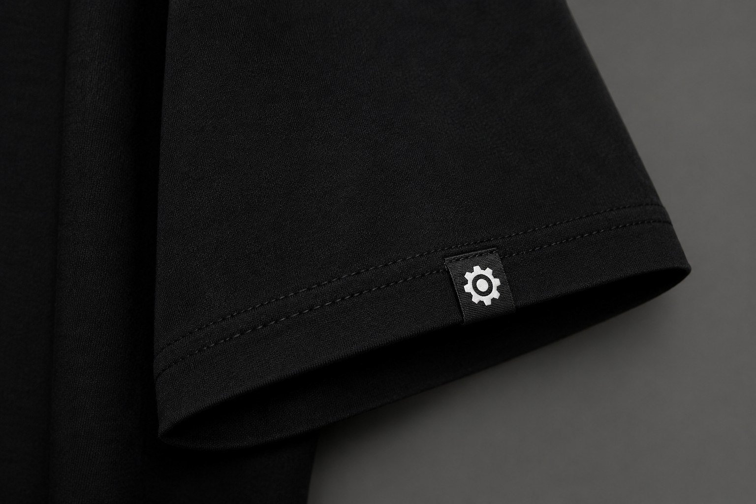 Sleeve cuff with woven gear emblem patch